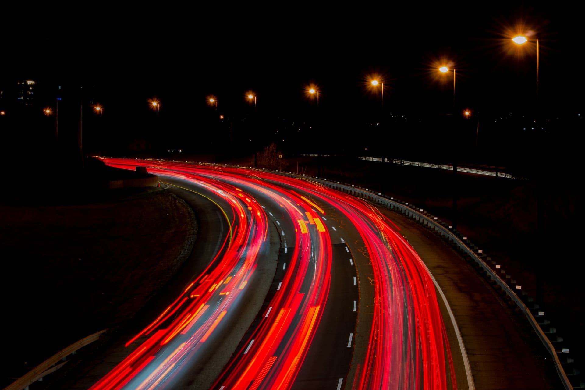 Nachtelijke snelweg met rode lichtsporen